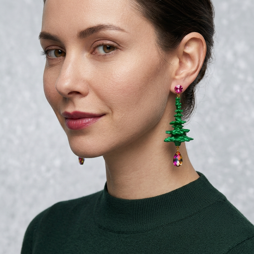 Model trägt grüne Holy Tree Weihnachtsbaum-Ohrringe von Tukadu mit pinkfarbenen Kristallakzenten und schillernden Tropfen.